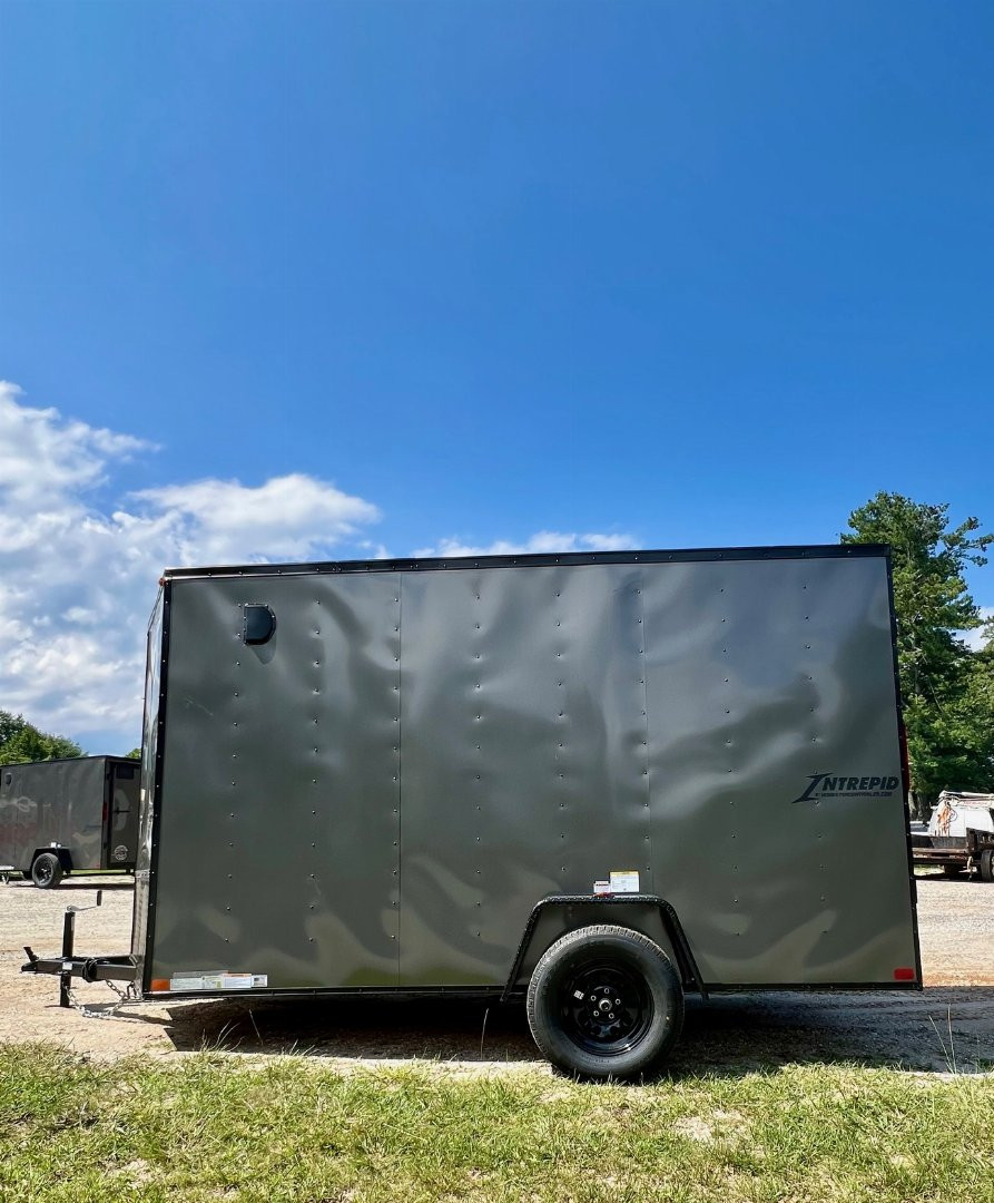 New 2025 HOMESTEADER TRAILER / INTREPID SERIES / 6' WIDE X 12' LONG / 6'6" INTERIOR HEIGHT / .030 CHARCOAL GRAY ALUMINUM W/ BLACK OUT PKG / 32" SIDE DOOR W/ RV LOCK / RAMP REAR DOOR / 4-D RINGS / 16" O/C WALL POST
