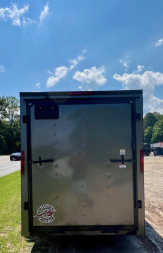 New 2025 HOMESTEADER TRAILER / INTREPID SERIES / 6' WIDE X 12' LONG / 6'6" INTERIOR HEIGHT / .030 CHARCOAL GRAY ALUMINUM W/ BLACK OUT PKG / 32" SIDE DOOR W/ RV LOCK / RAMP REAR DOOR / 4-D RINGS / 16" O/C WALL POST